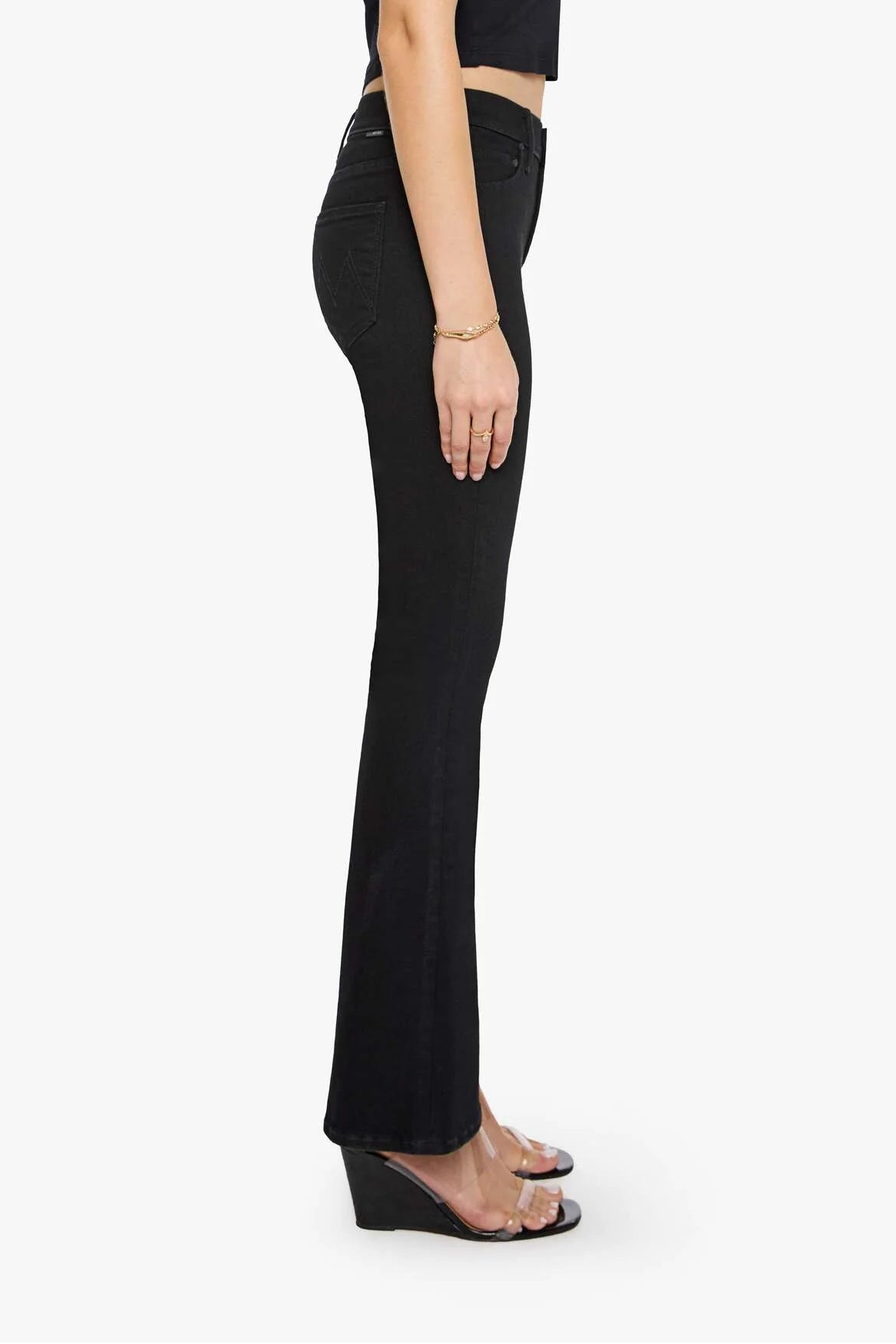 Woman wearing a black sleeveless top and flared pants on a white background