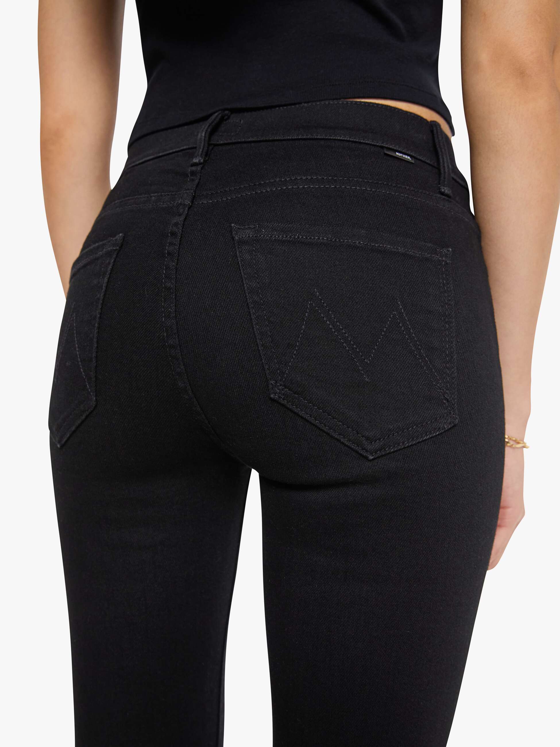 Person wearing black jeans on a white background