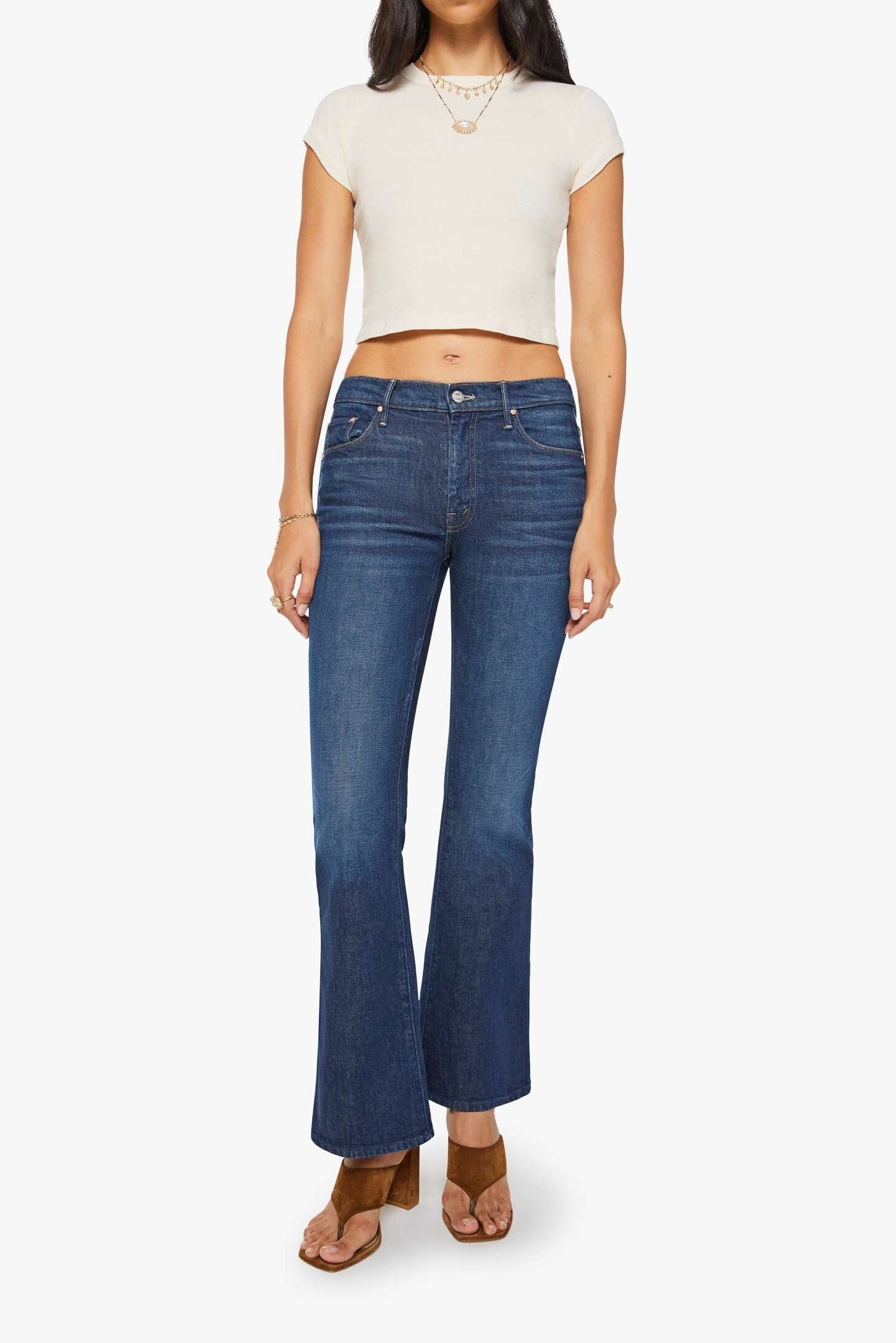 Woman wearing blue jeans and a white top on a white background