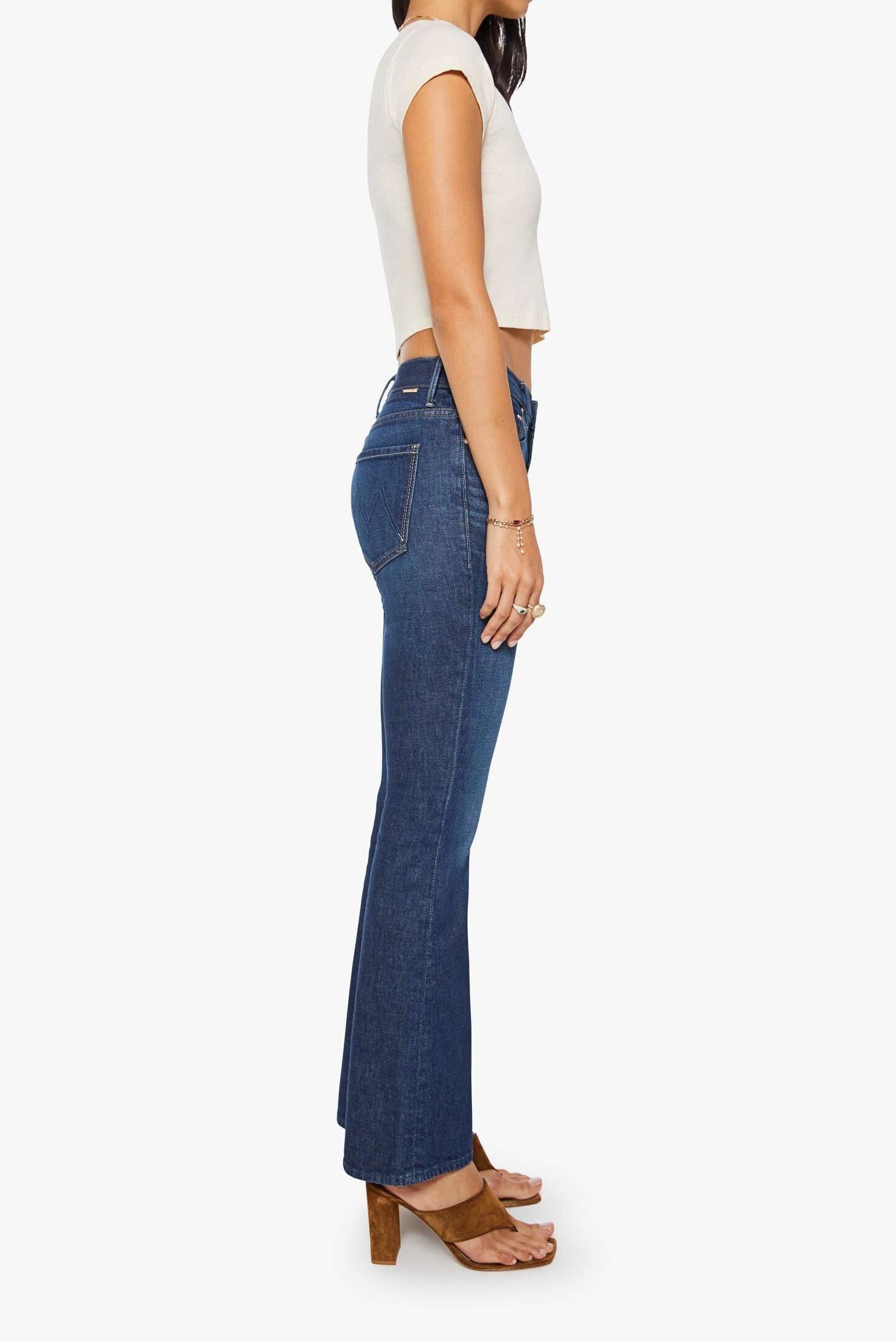 Woman wearing blue jeans and a white top on a white background