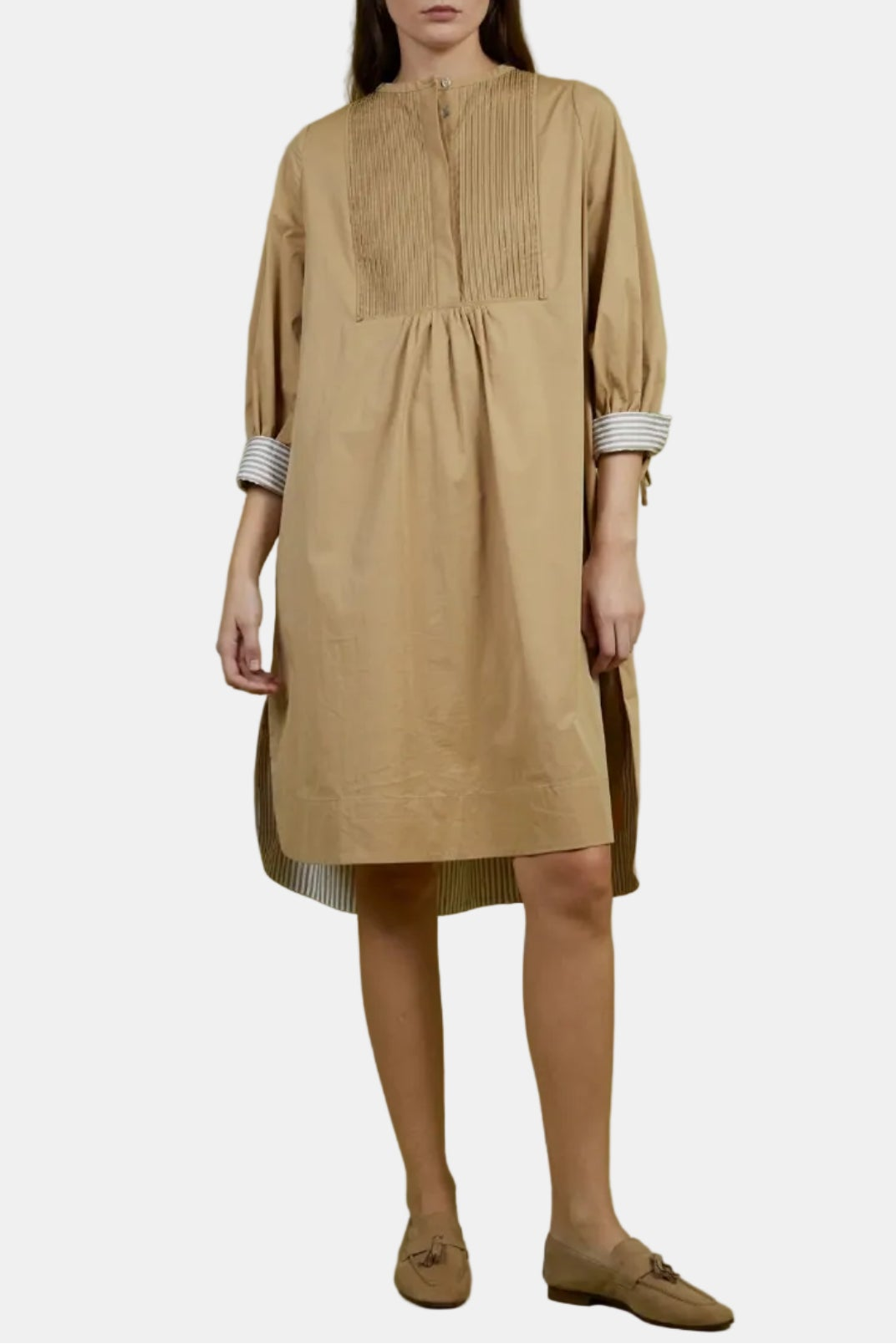 Woman wearing a beige dress against a green background