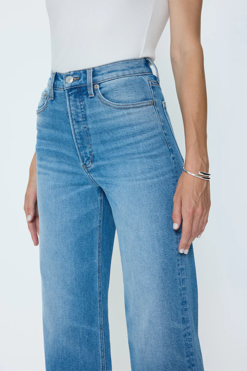 Blue jeans worn by a person on a white background