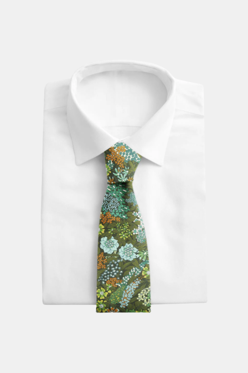 A patterned necktie with a green, blue, and orange floral design, styled on a white dress shirt against a light gray background.