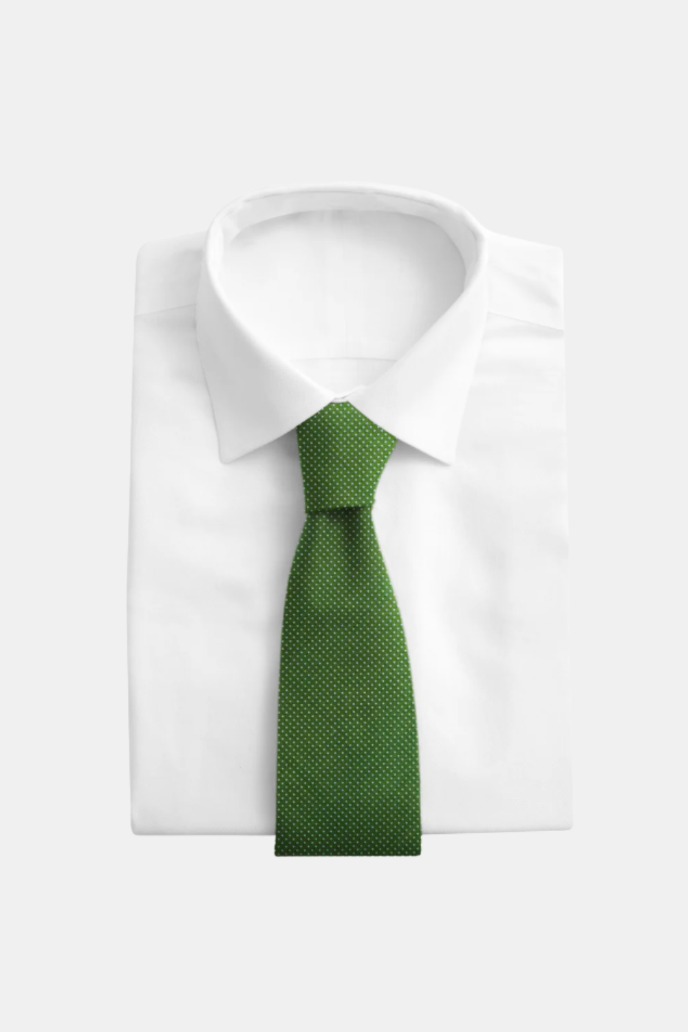 A green necktie with a fine micro-dot pattern, neatly tied and displayed on a folded white dress shirt against a light gray background.