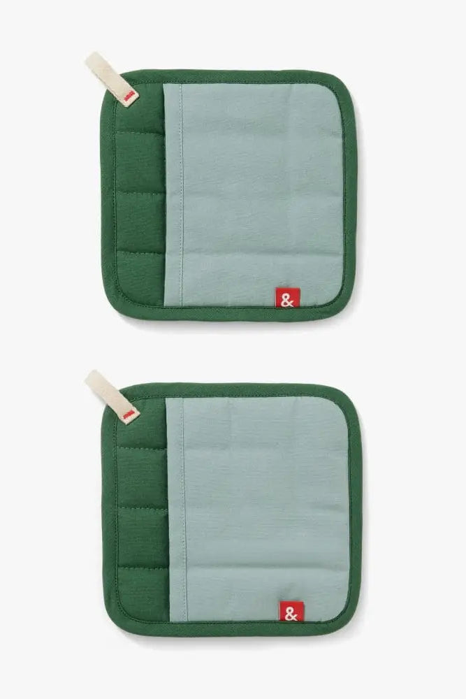 Two green pot holders with gray centers on a white background