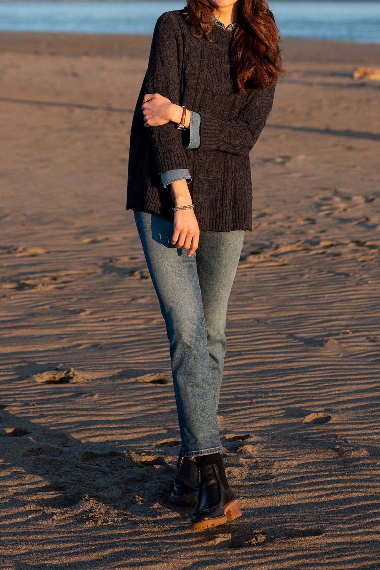 Woman standing on a beach with the Golden Gate Bridge in the background