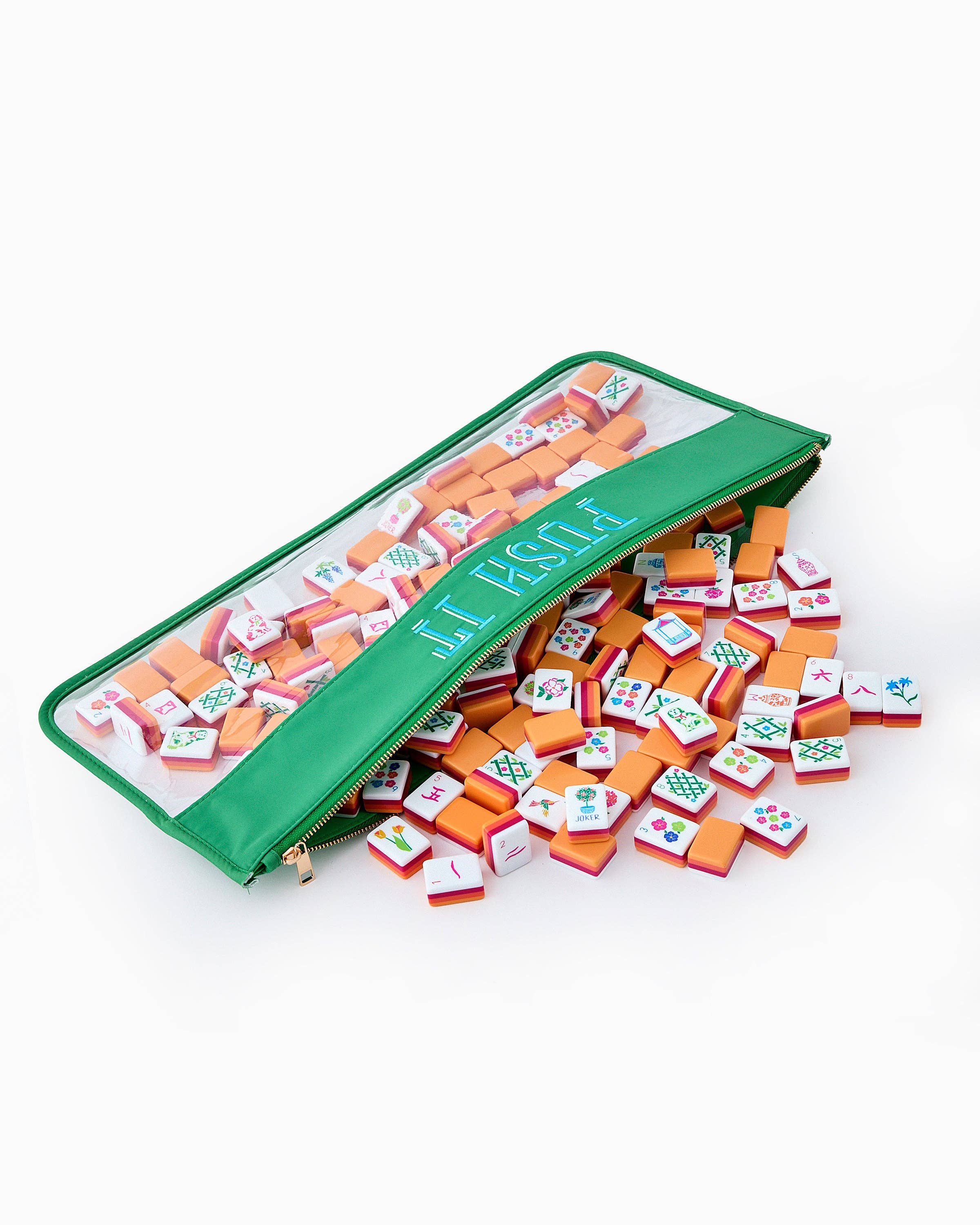 Miniature mahjong tiles spilling out of a green carrying case on a white background