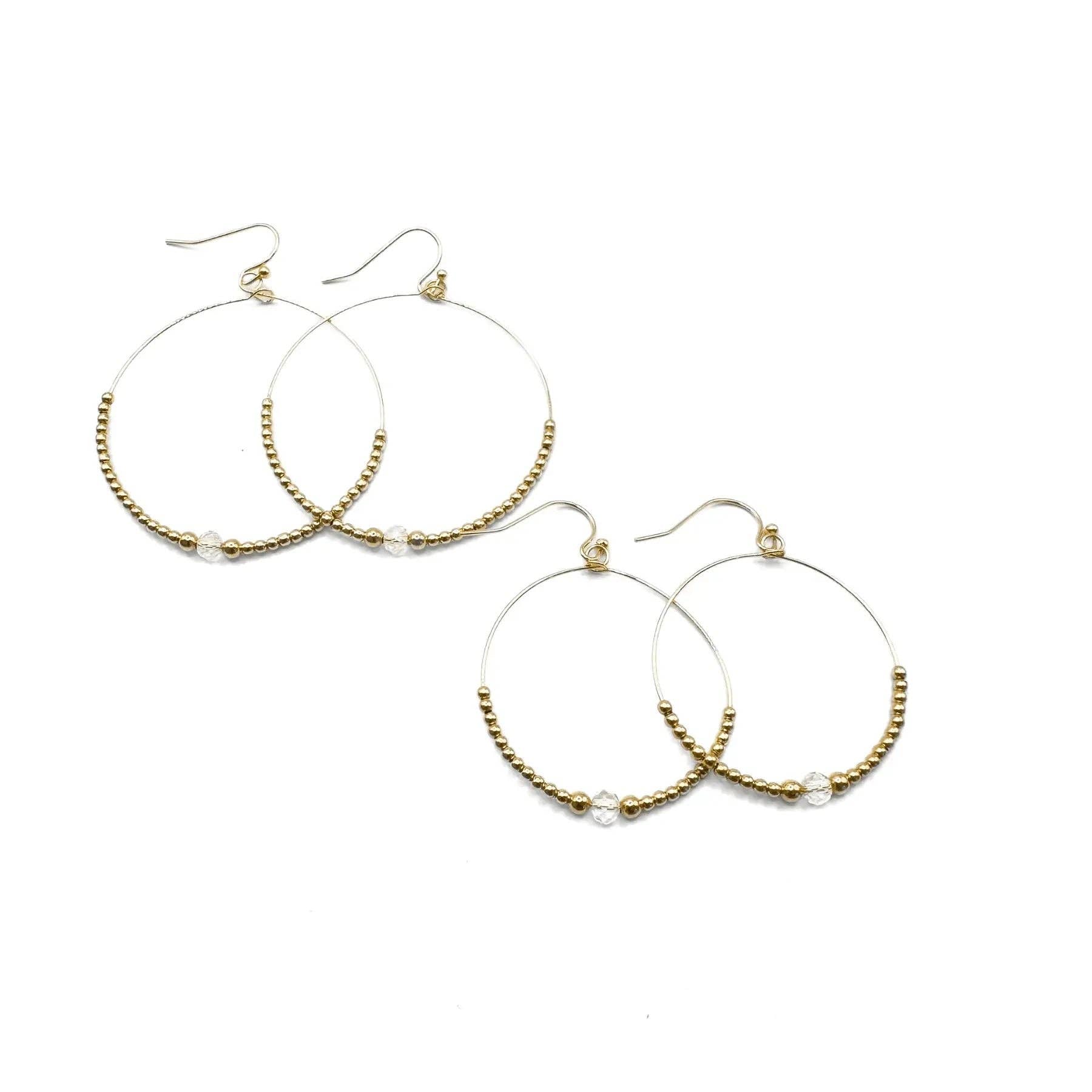 Gold hoop earrings with beaded accents on a white background