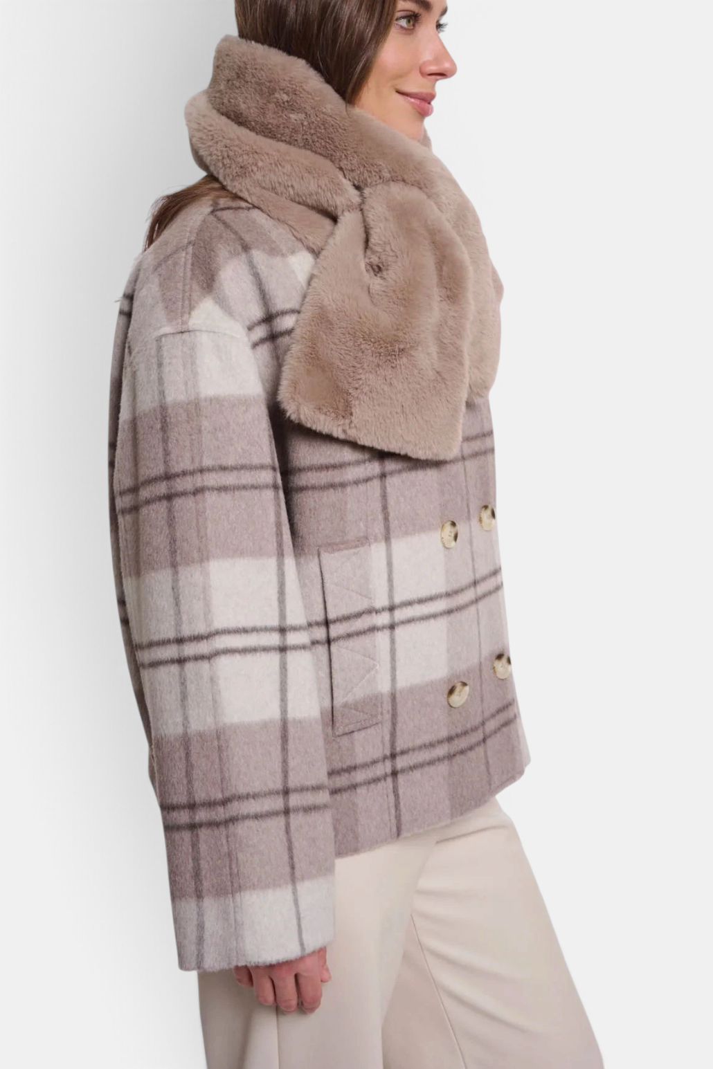 The Copper Shed Stip beige faux fur scarf worn over a plaid coat, featuring a soft texture and open pull-through loop.