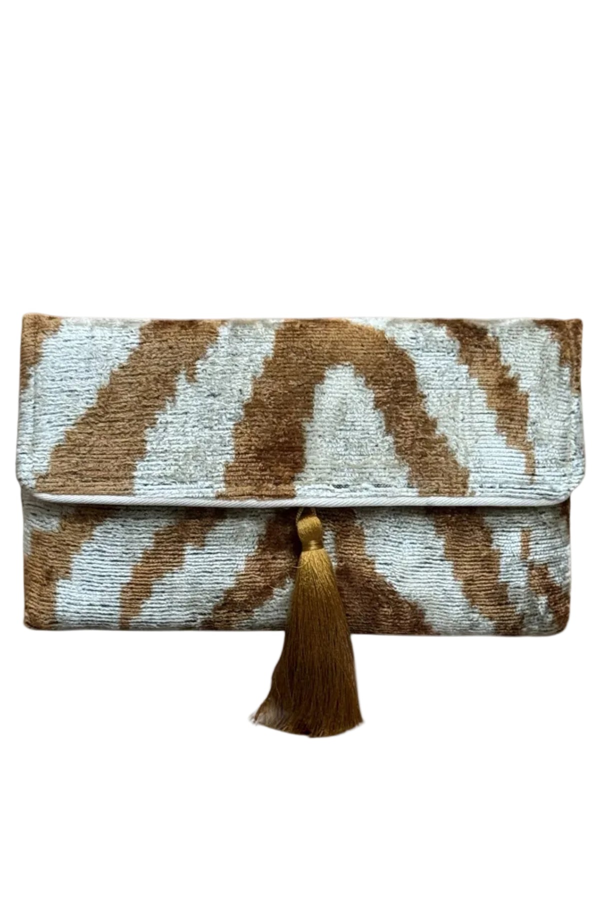 A textured clutch bag with a brown and off-white ikat pattern and a matching brown tassel, shown on a plain white background.
