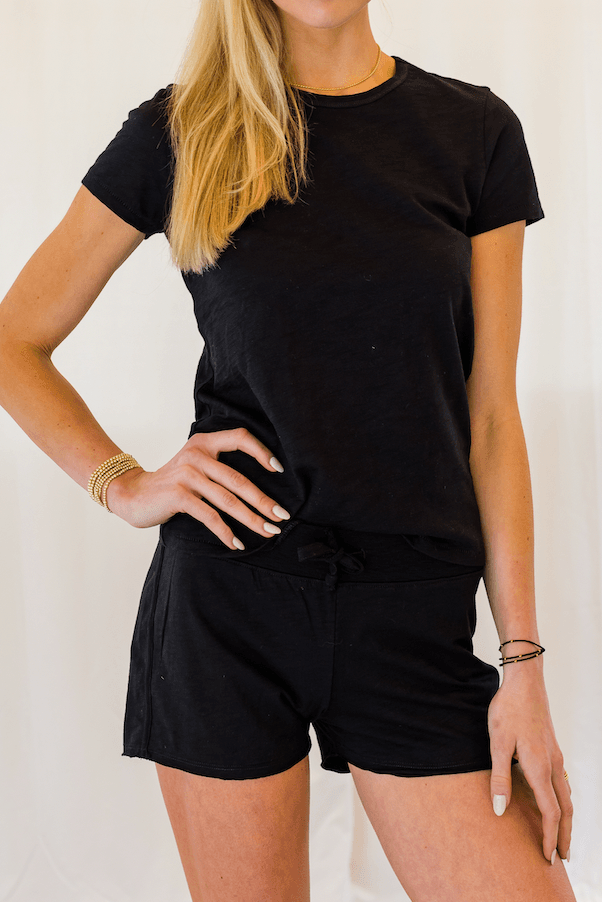 Woman wearing a black outfit against a white background