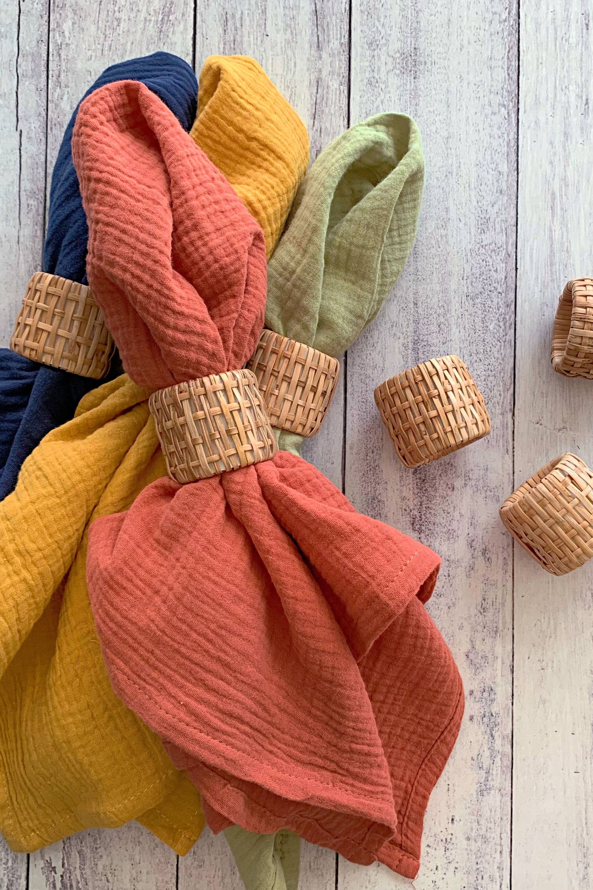 Colorful textured cloths with wooden rings on a wooden surface