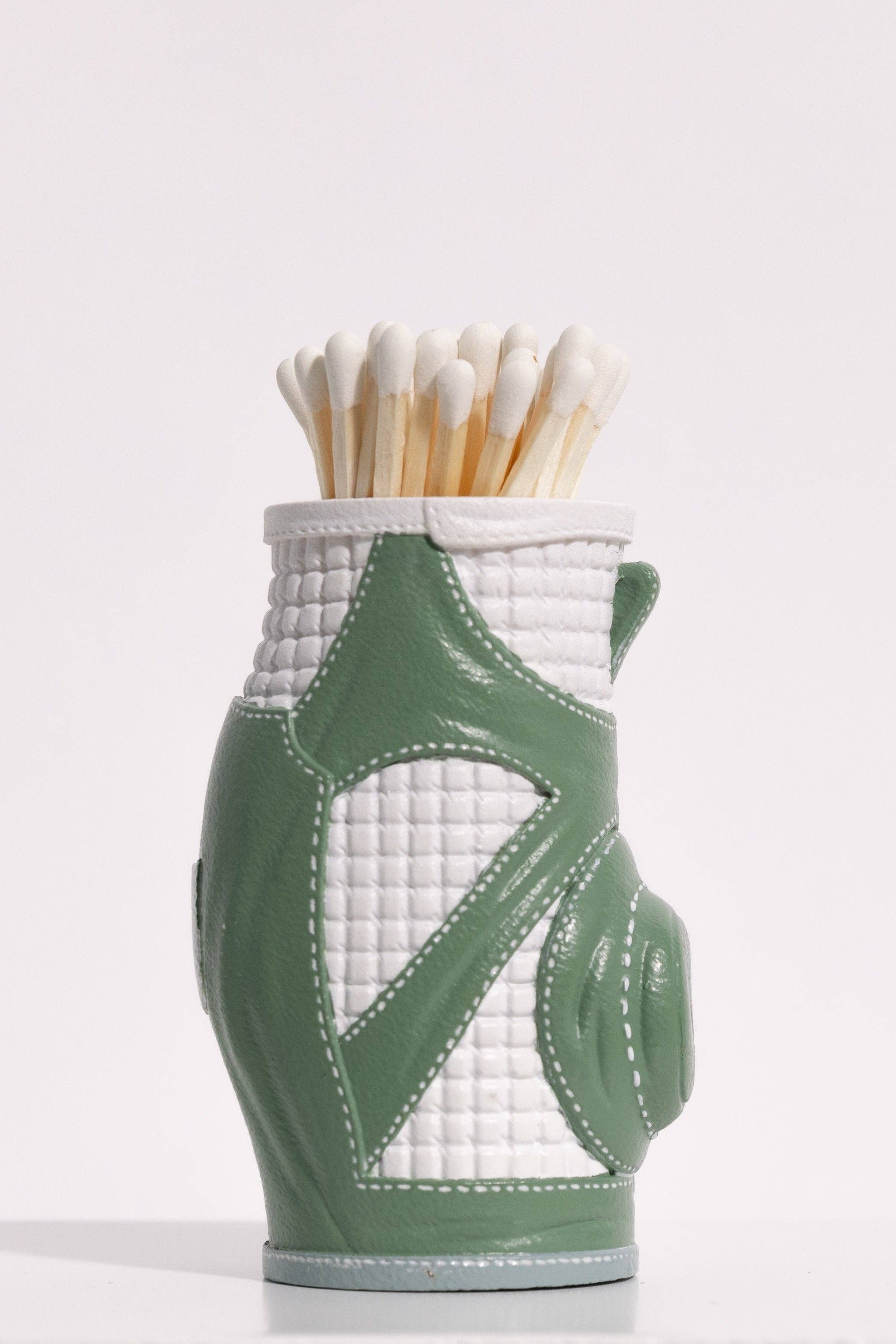 Matches in a green and white quilted match striker on a white background