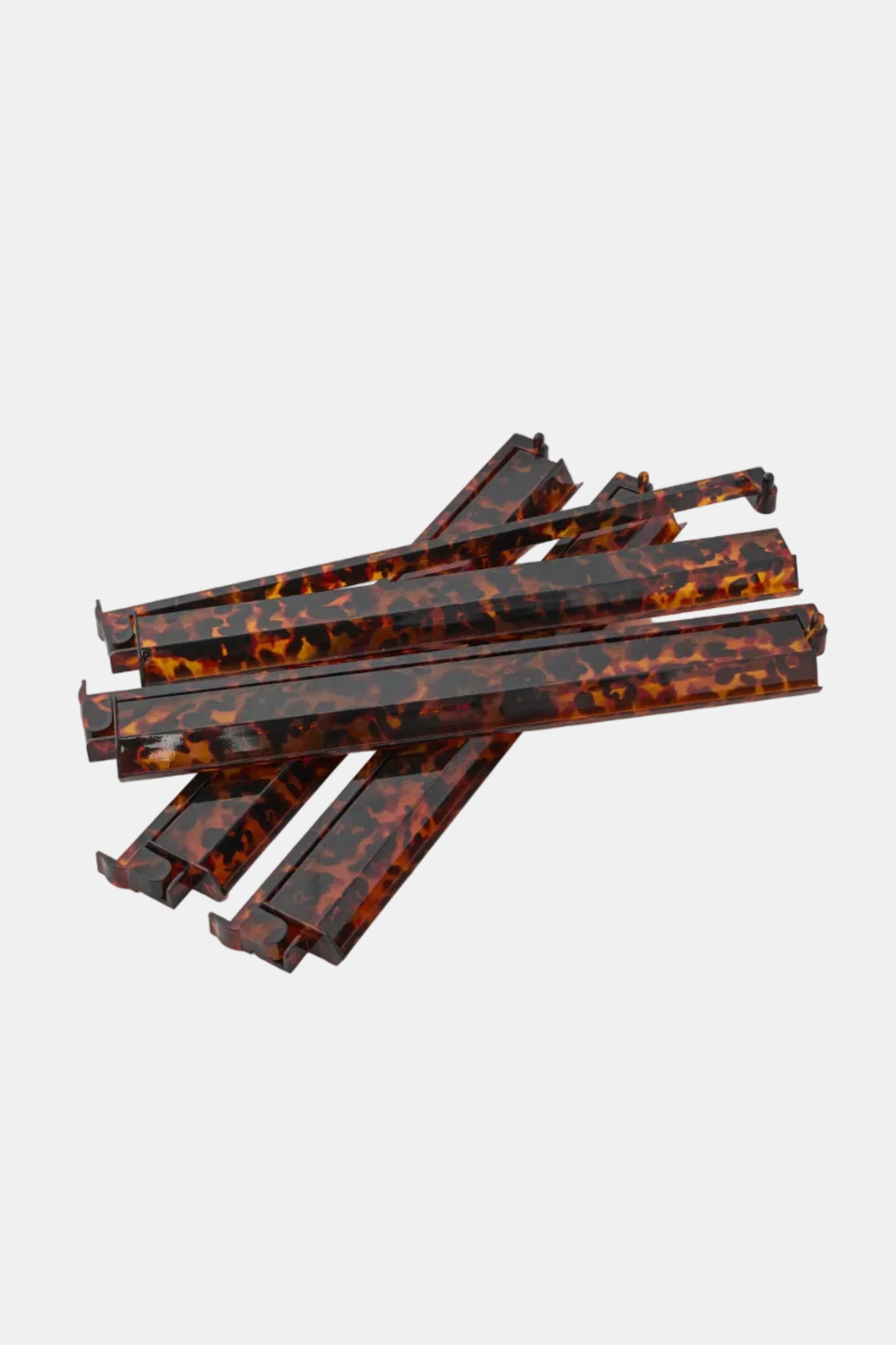 Set of tortoiseshell-patterned plastic straws on a white background