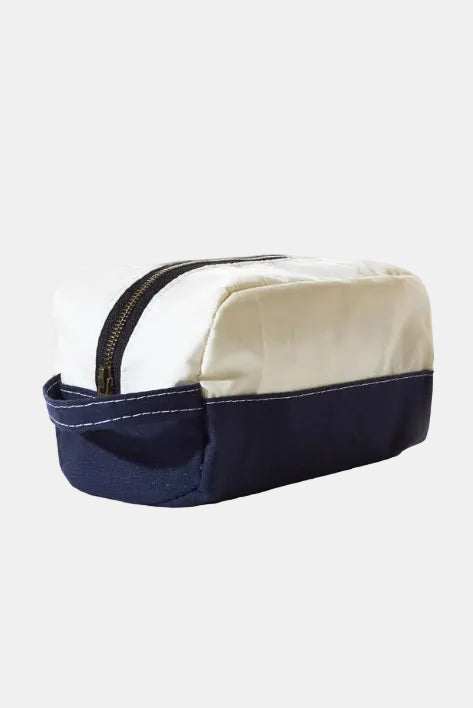 Two-toned beige and navy toiletry bag on a white background