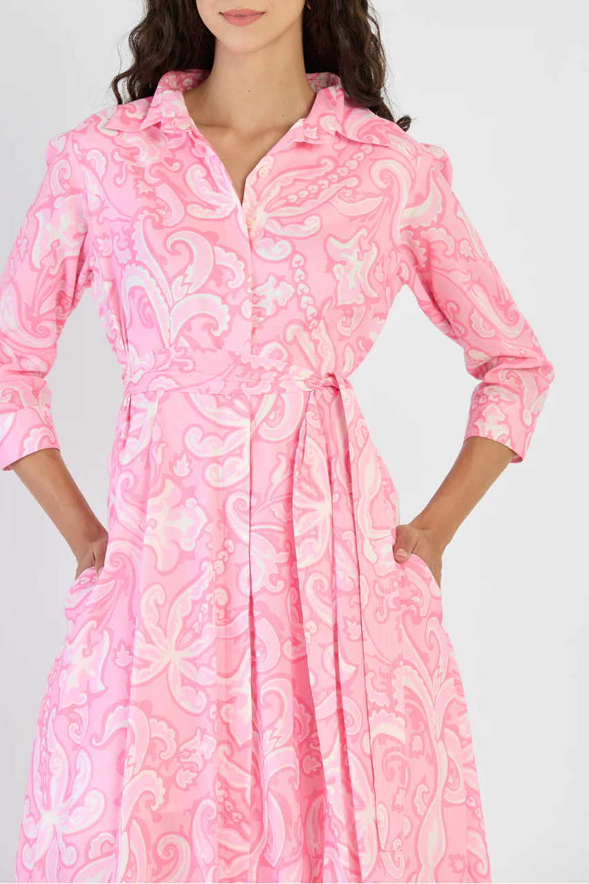 Woman wearing a pink patterned dress on a white background