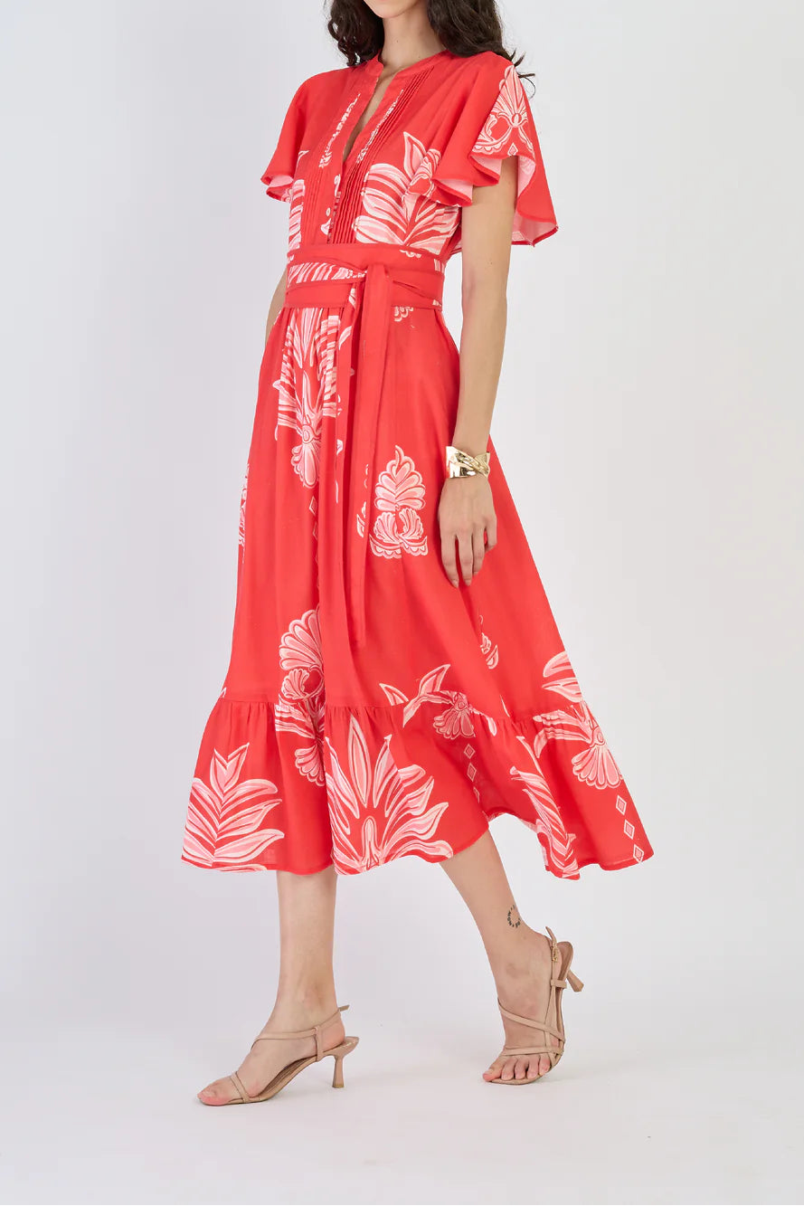 Woman wearing a red dress with white floral pattern on a white background