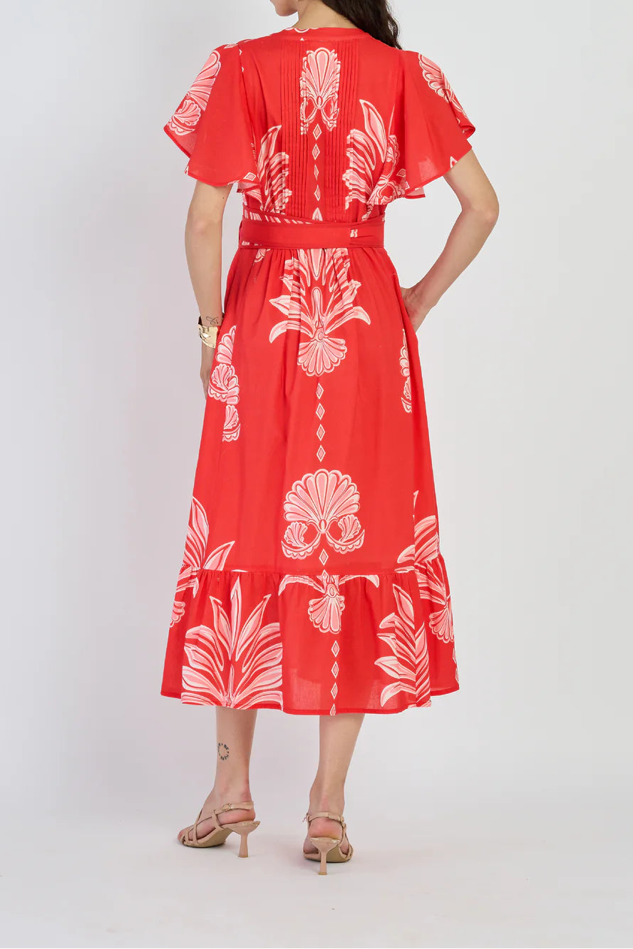 Woman wearing a red dress with white floral patterns on a white background