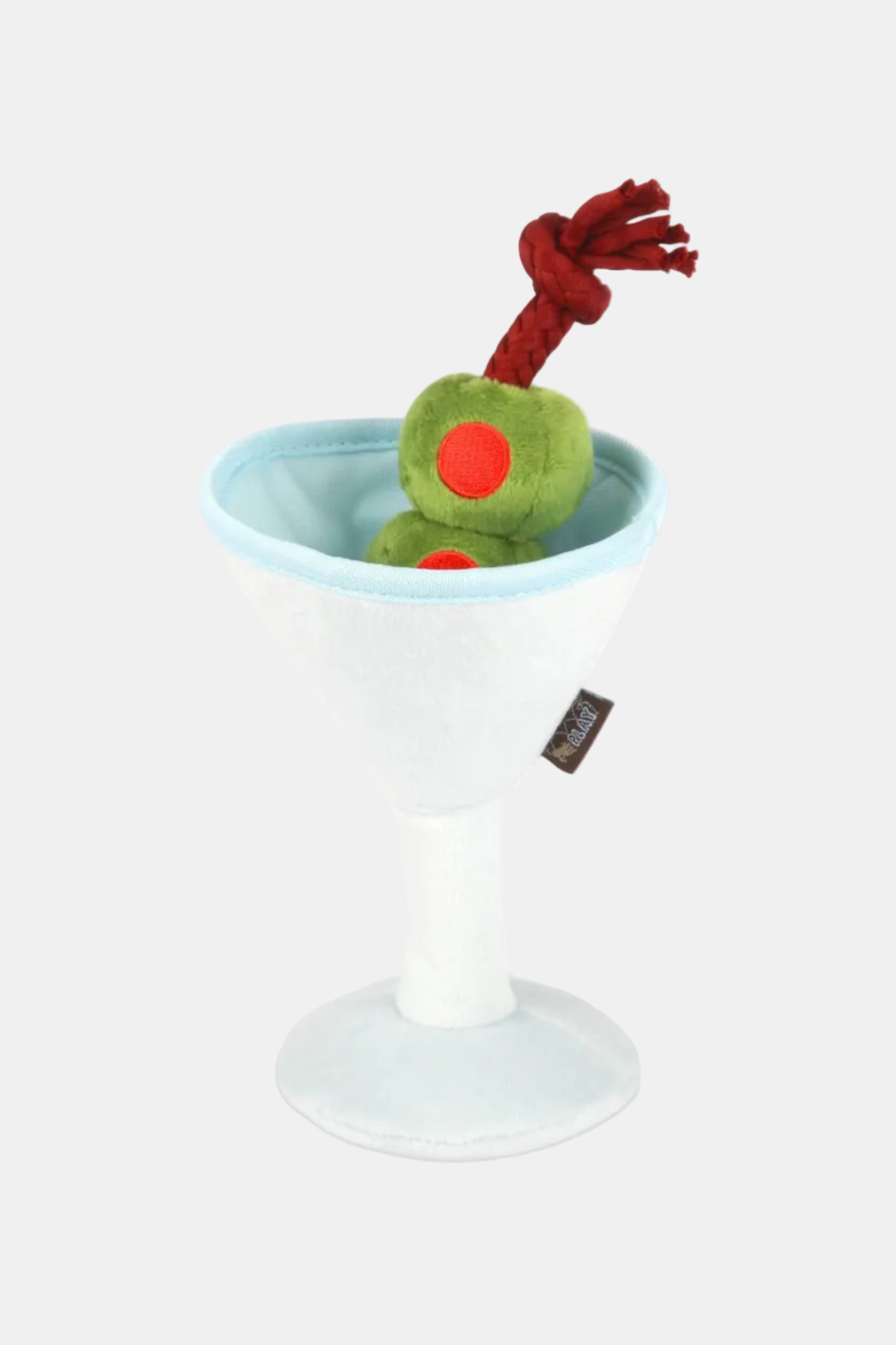 Plush toy resembling a green olive with a red dot in a martini glass on a white background