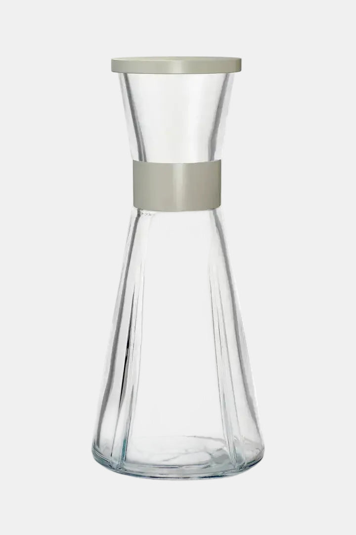 Clear glass carafe with a gray band and lid on a white background