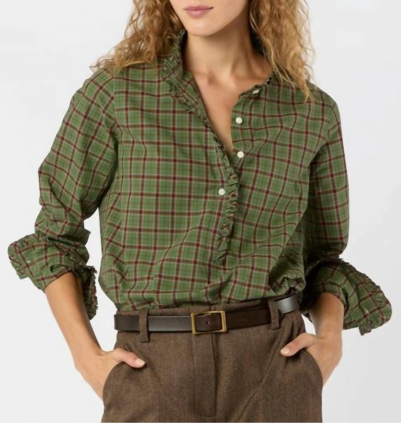 Woman wearing a green plaid shirt with rolled-up sleeves on a white background