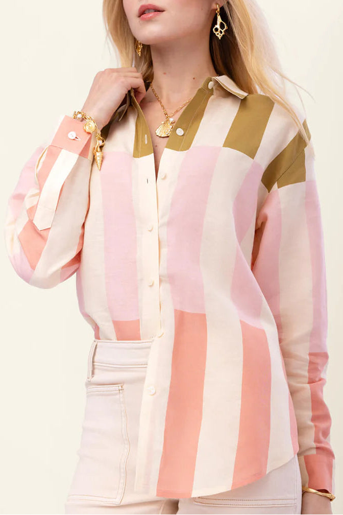 Woman wearing a colorful striped shirt with a plain background