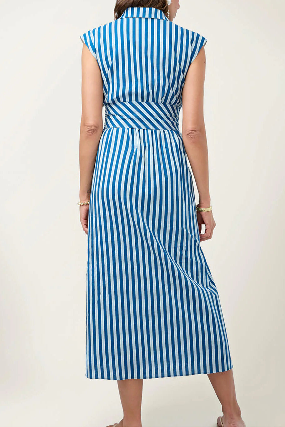 Woman wearing a blue and white striped dress on a plain background