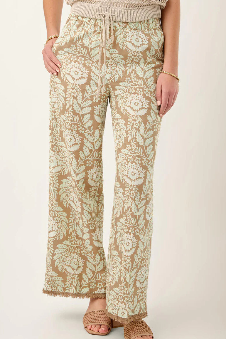 Floral patterned pants worn by a person on a plain background