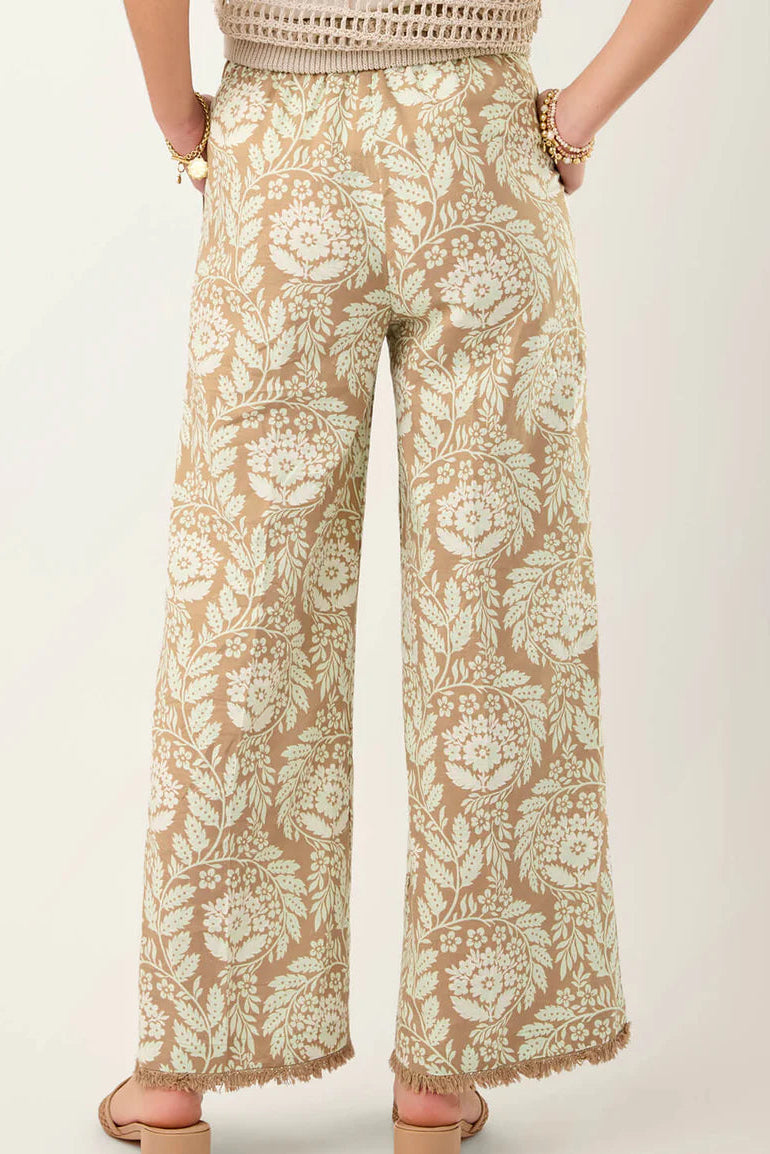 Floral patterned pants worn by a person on a plain background