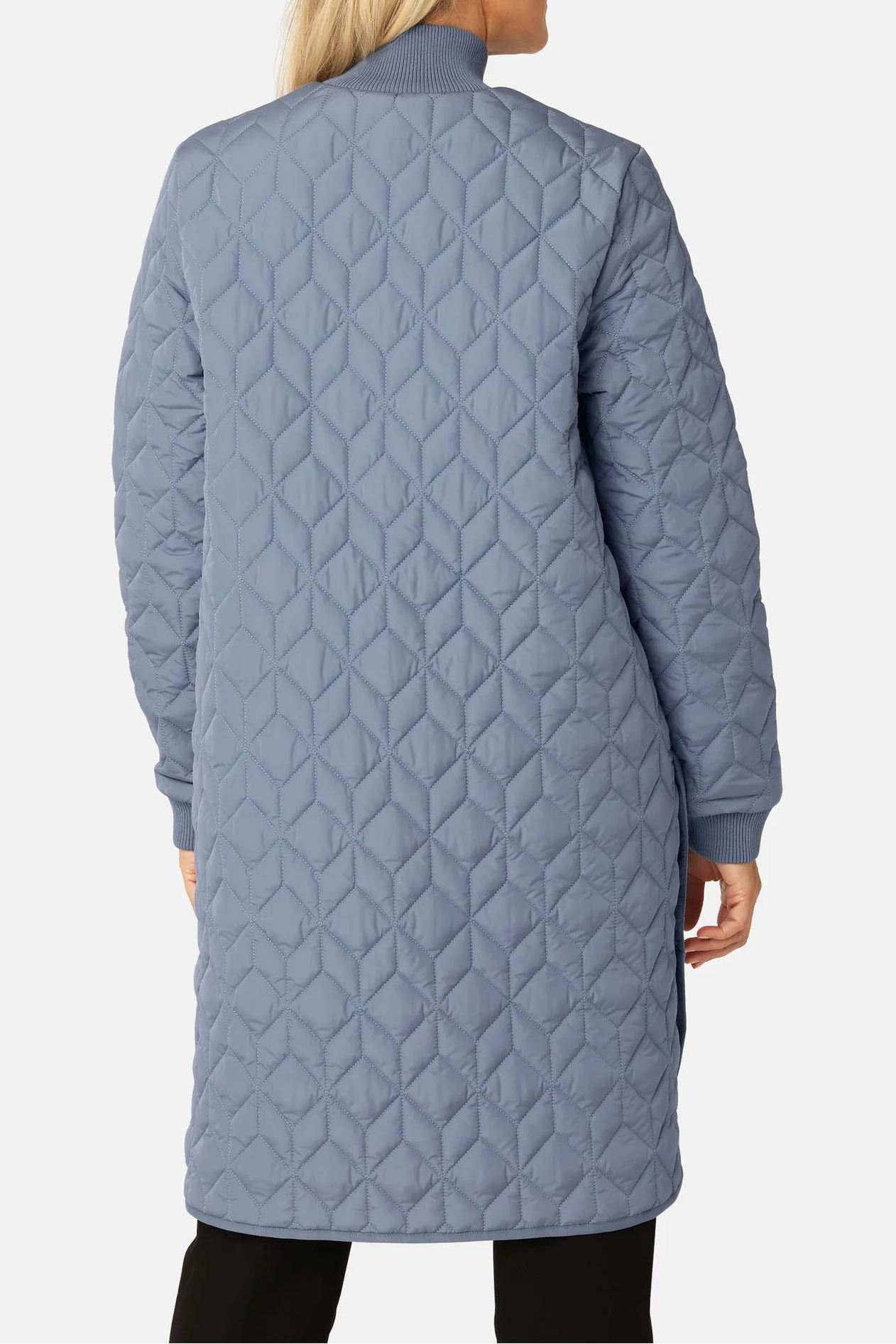 Person wearing a quilted blue coat on a white background