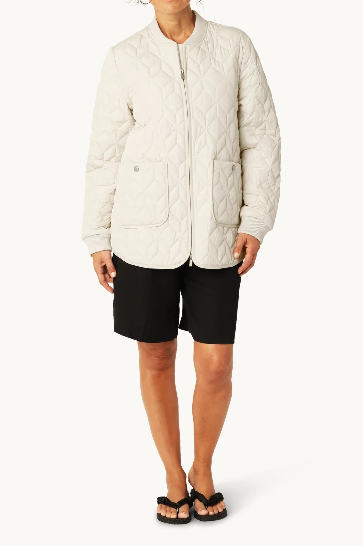 Woman wearing a white quilted jacket on a white background