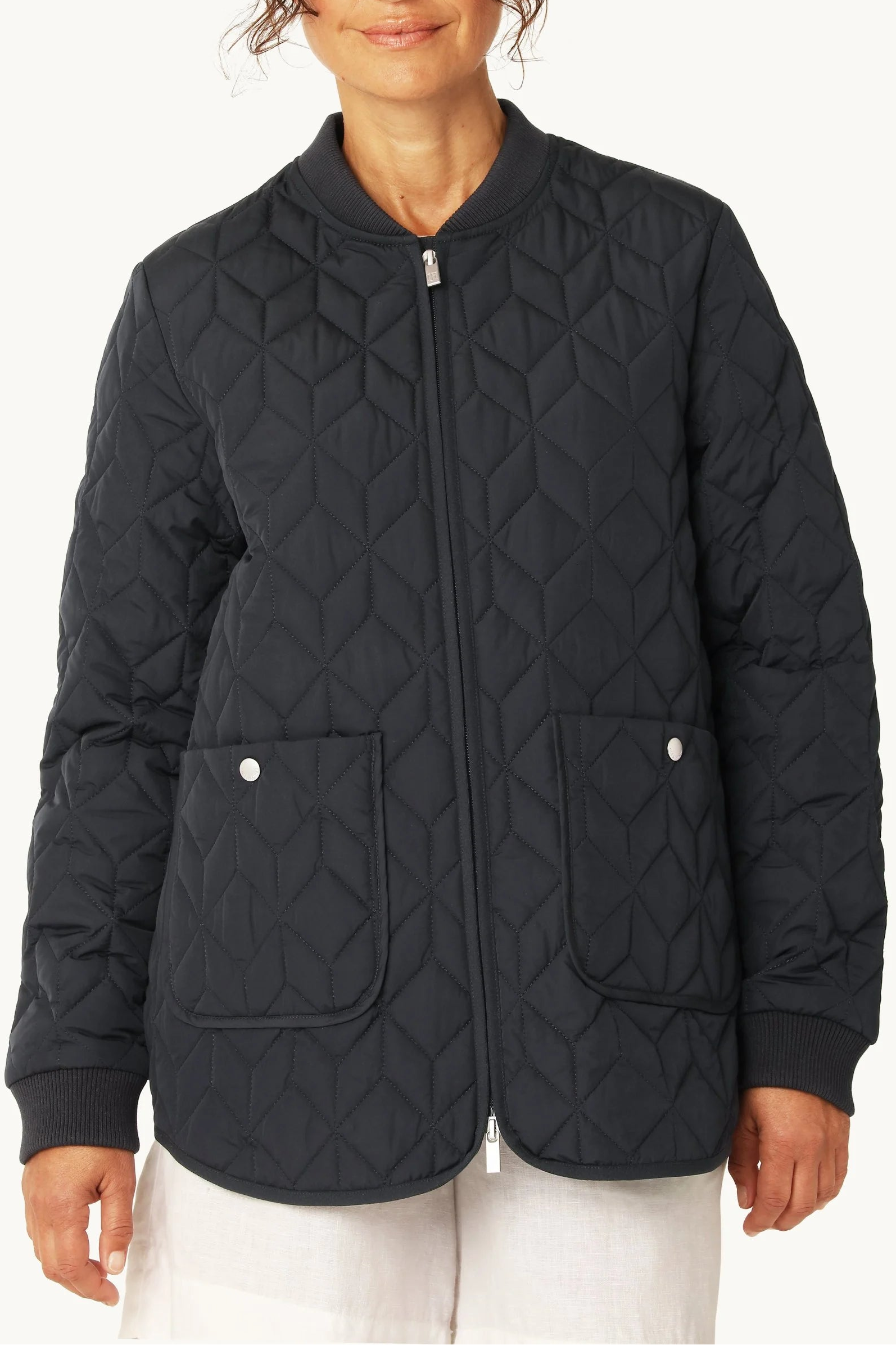 Woman wearing a black quilted jacket on a white background