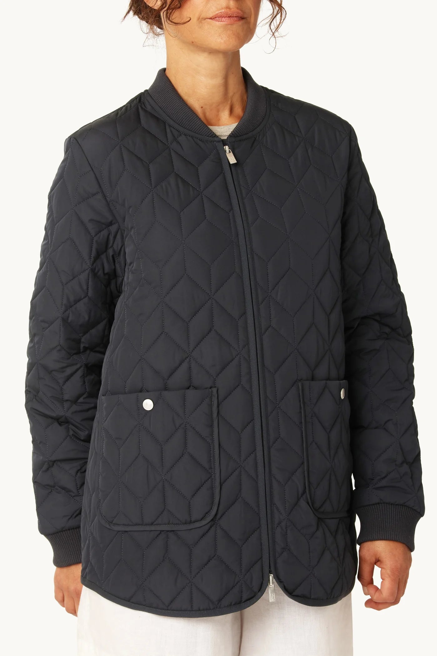 Person wearing a black quilted jacket on a white background