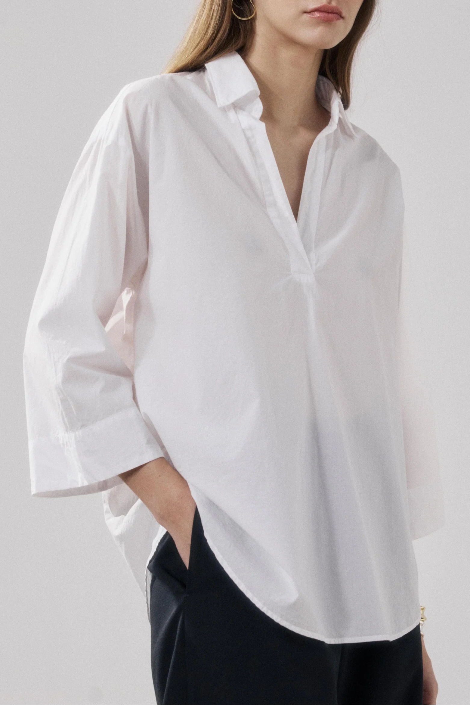 Woman wearing a white shirt against a plain background