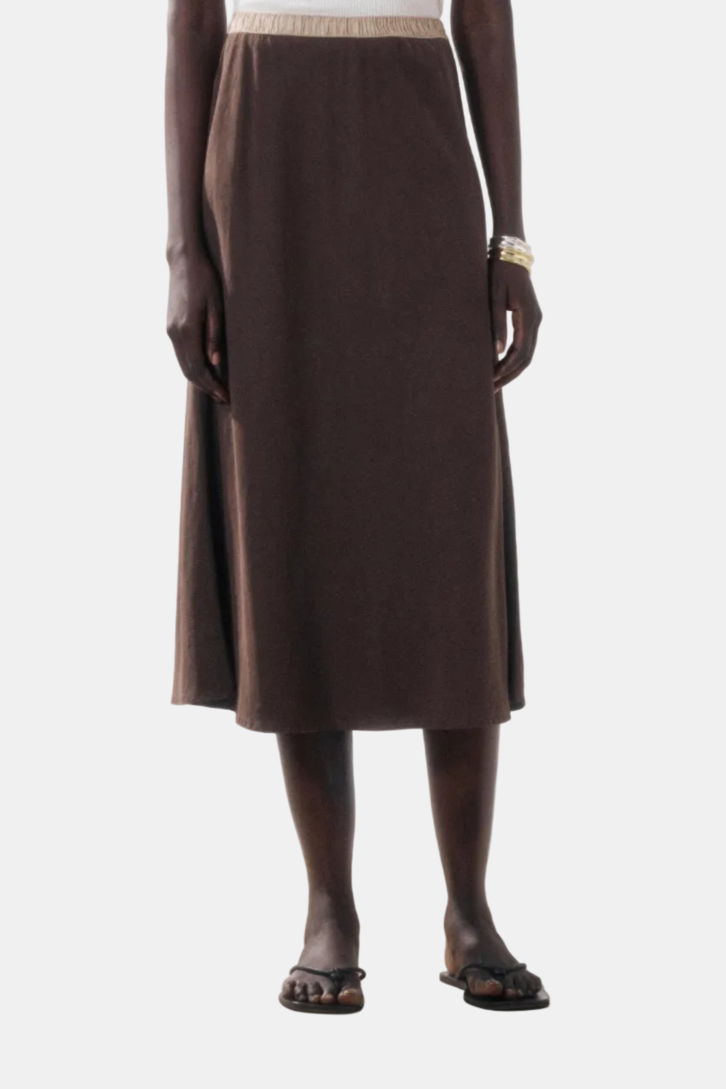 Person wearing a brown skirt on a plain background