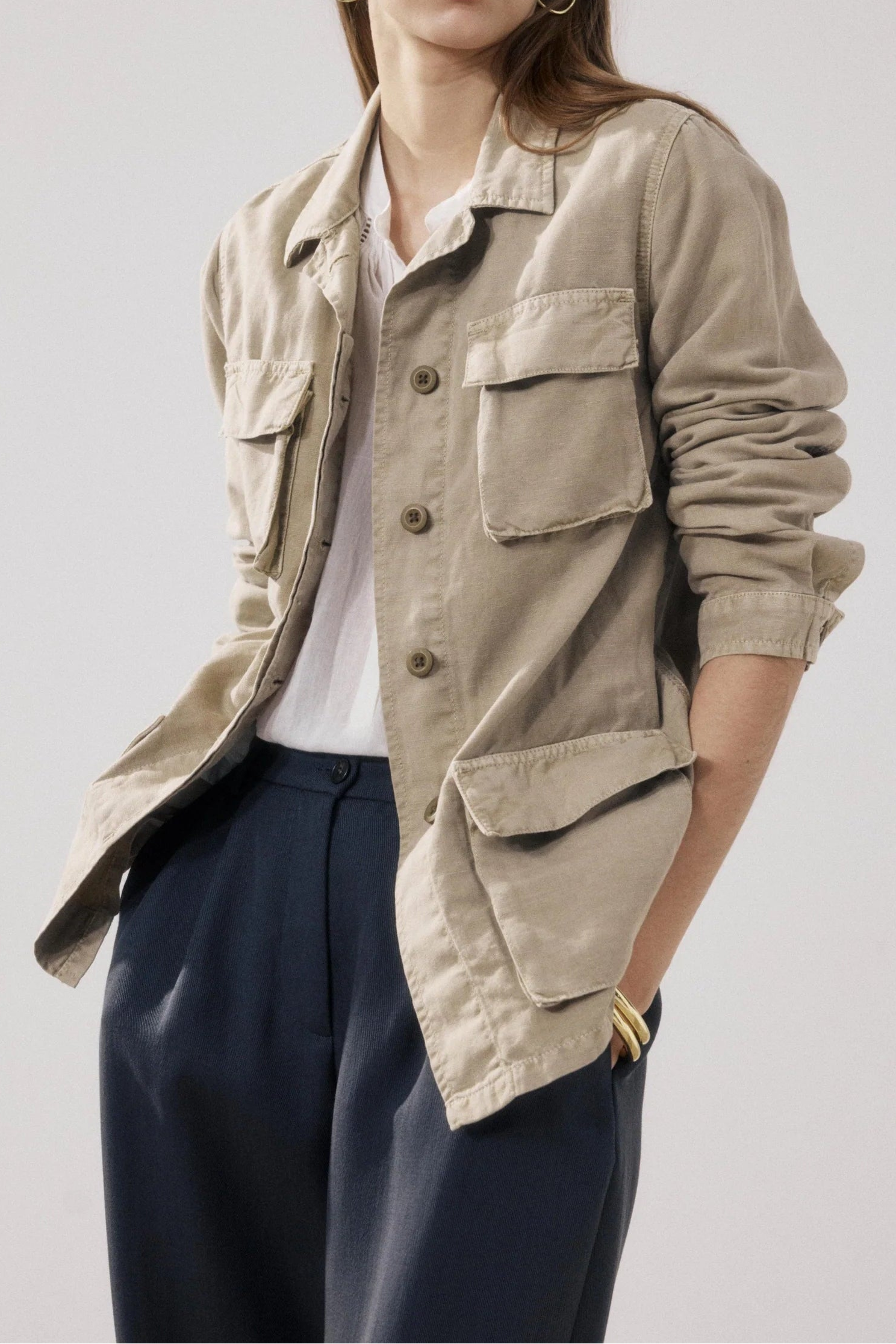 Woman wearing a beige jacket with a plain background