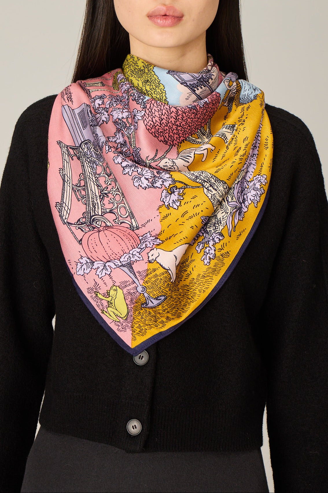 Woman wearing a colorful patterned scarf on a plain background