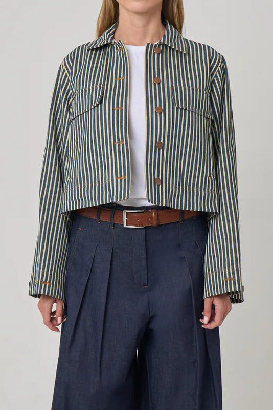Woman wearing a striped shirt and wide-leg pants on a plain background