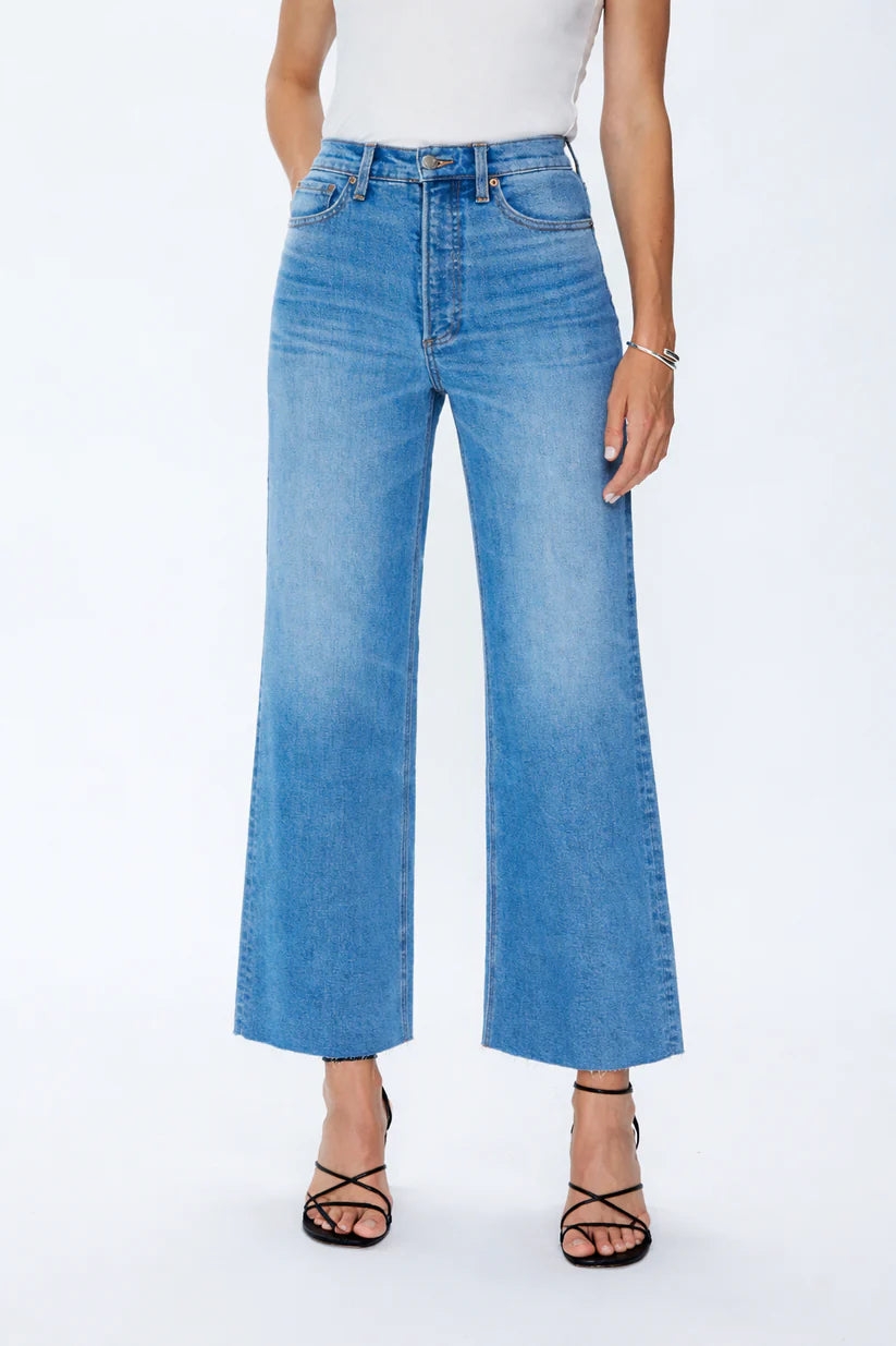 Person wearing light blue jeans on a white background