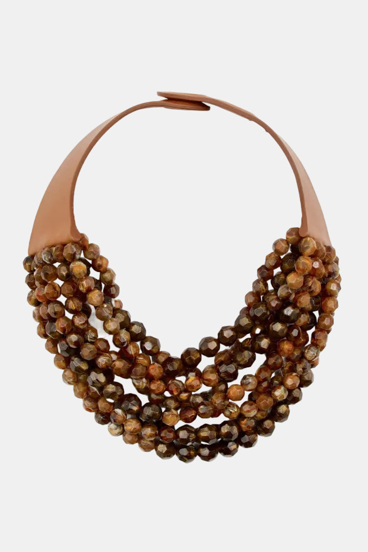 A multi-strand statement necklace featuring faceted brown and amber beads with tan leather loops at the top, shown against a plain white background.