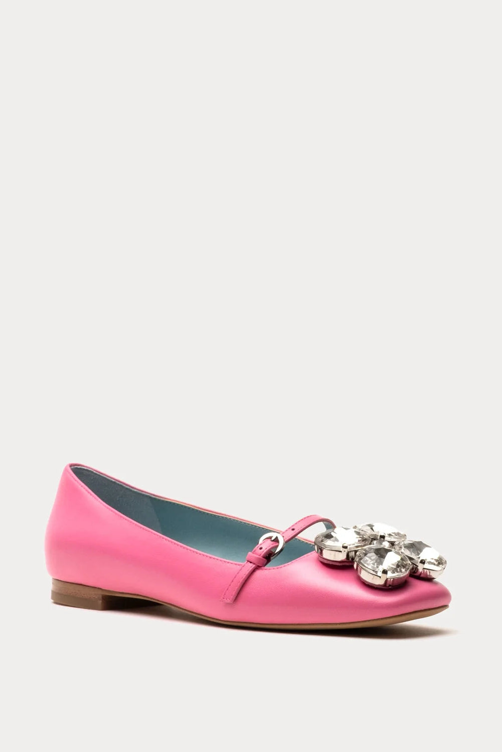 Pink flat shoe with embellishments on a white background