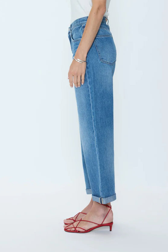 Woman wearing a white top and blue jeans on a white background