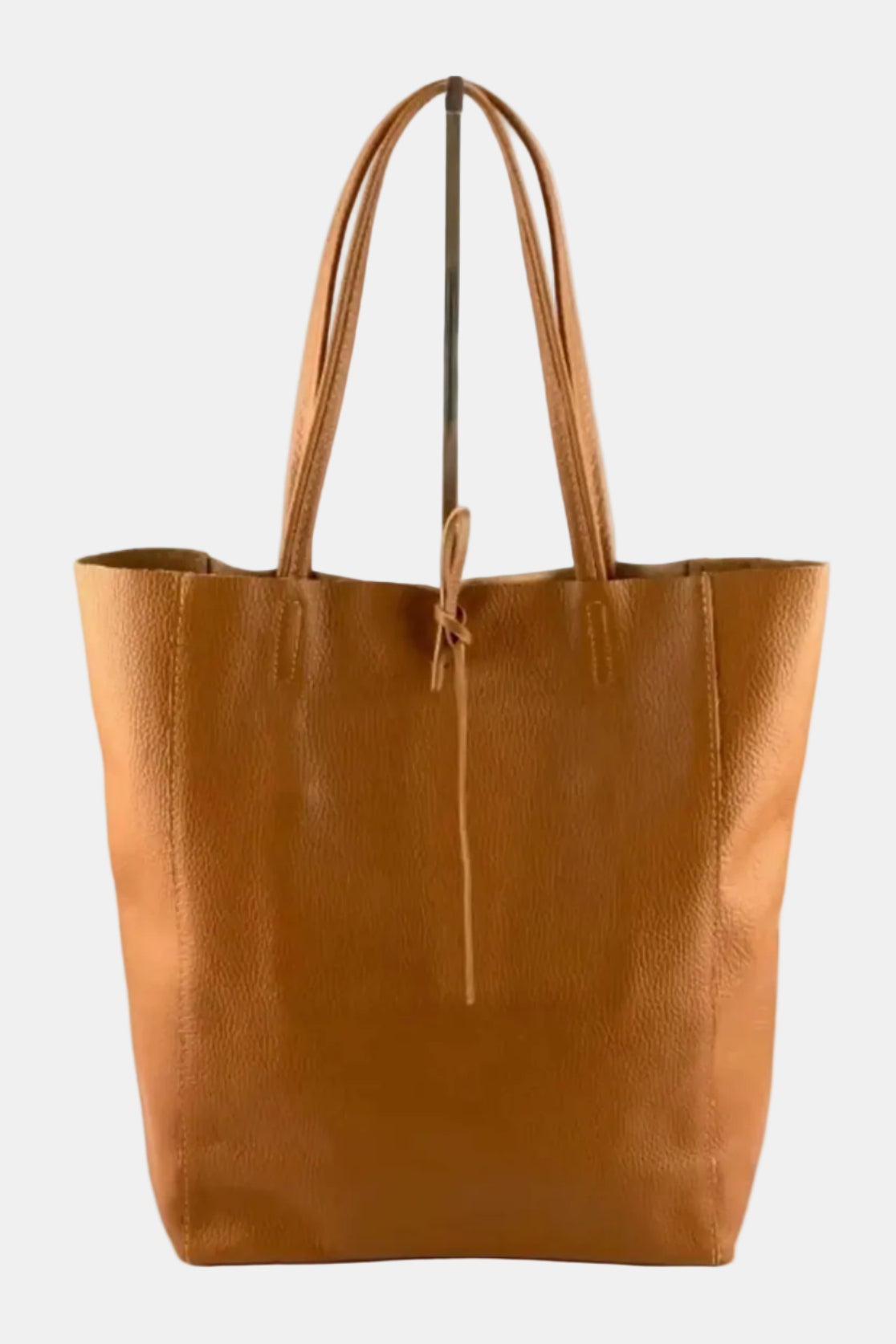 A tan pebbled leather tote bag with dual shoulder straps and a drawstring detail at the top center, shown against a plain white background.