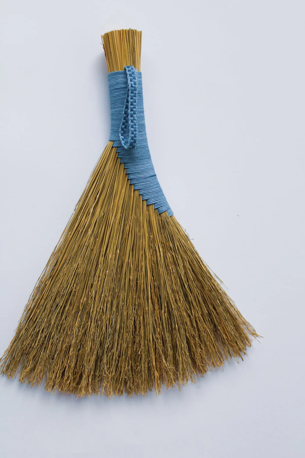 Broom with blue handle on a white background