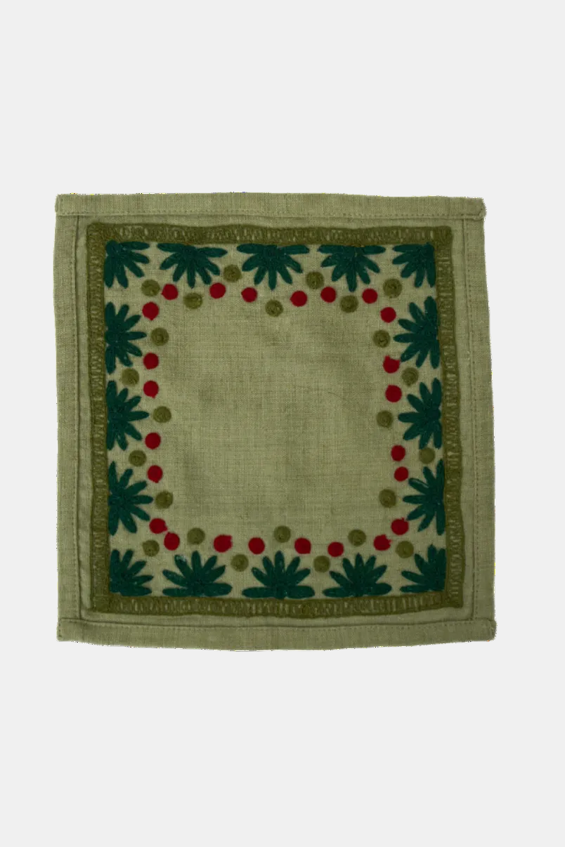 Decorative square mat with green leaf pattern on a beige background