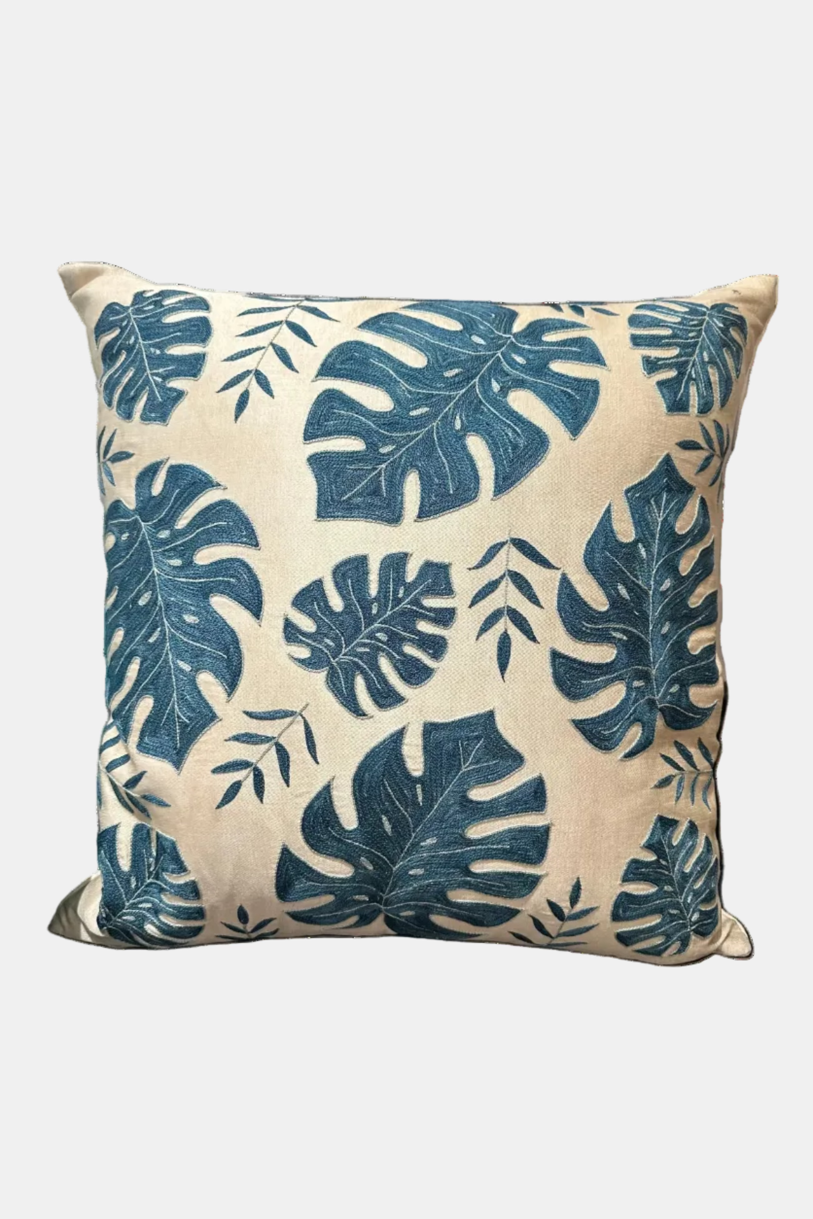 Decorative pillow with blue leaf pattern on a chair