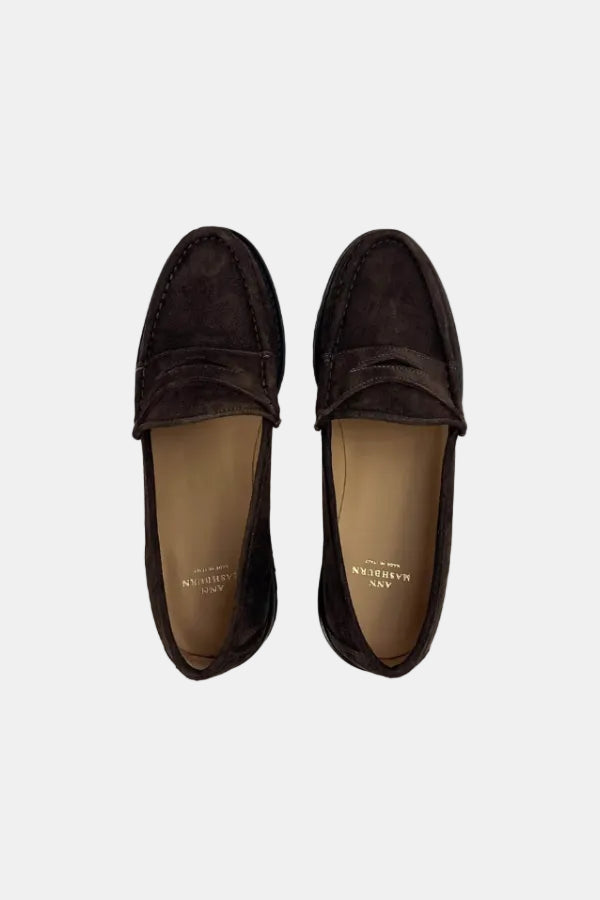 A pair of dark brown suede penny loafers shown from a top-down view on a solid white background. The insoles are tan and feature the brand name 'ANN HARRISON' printed in gold.