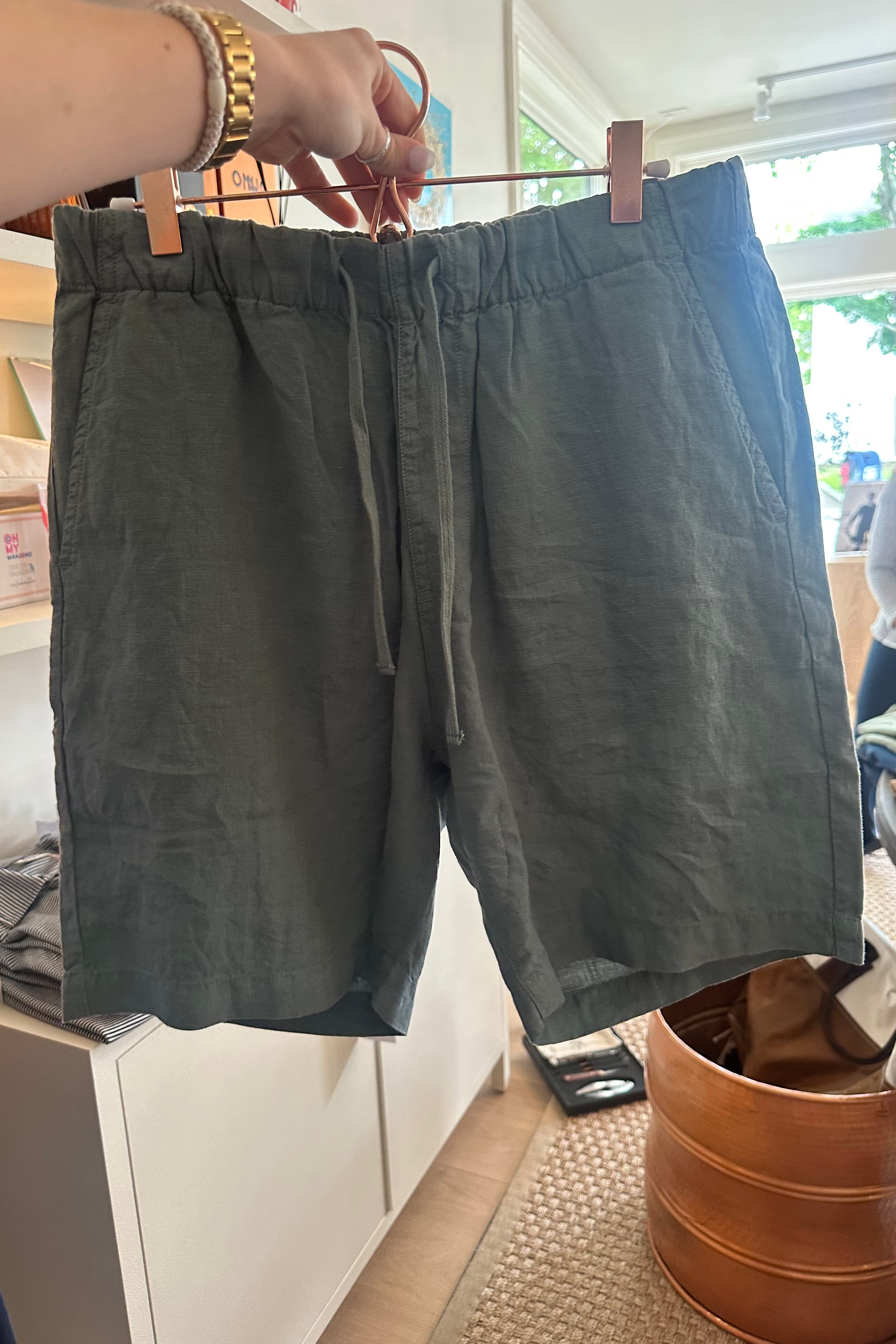 Green shorts hanging on a rack indoors