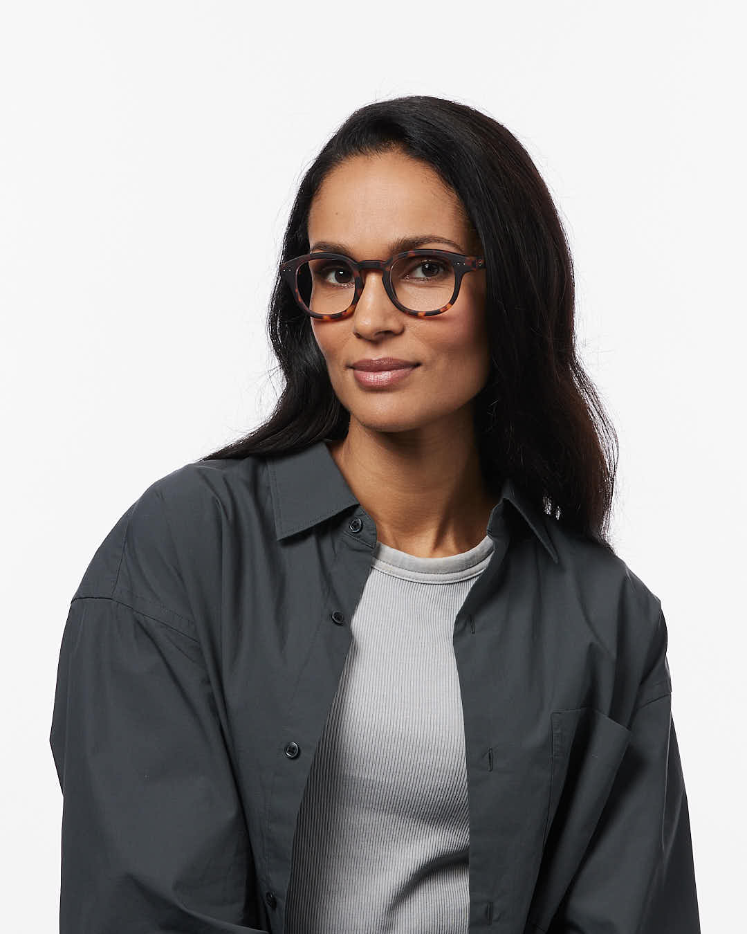 Woman wearing glasses and a dark jacket on a white background