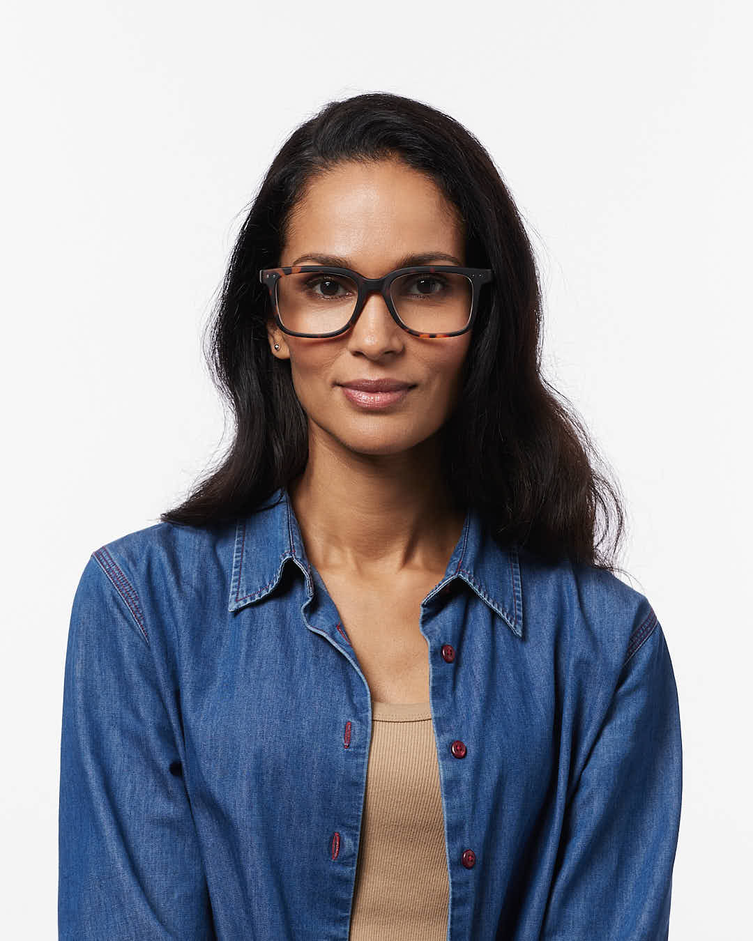 Woman wearing glasses and a blue denim shirt on a white background